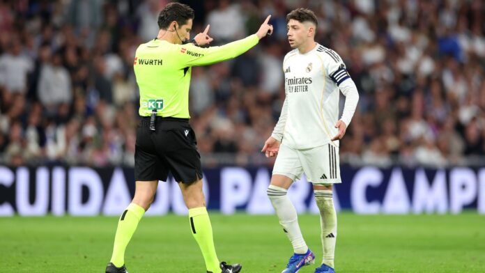Federico Valverde of Real Madrid reacts towards Referee Jose Munuera after being shown a red card during the LaLiga EA Sports match between Real Madrid CF and Atletico de Madrid at Estadio Santiago Bernabeu on March 22, 2026 in Madrid, Spain.